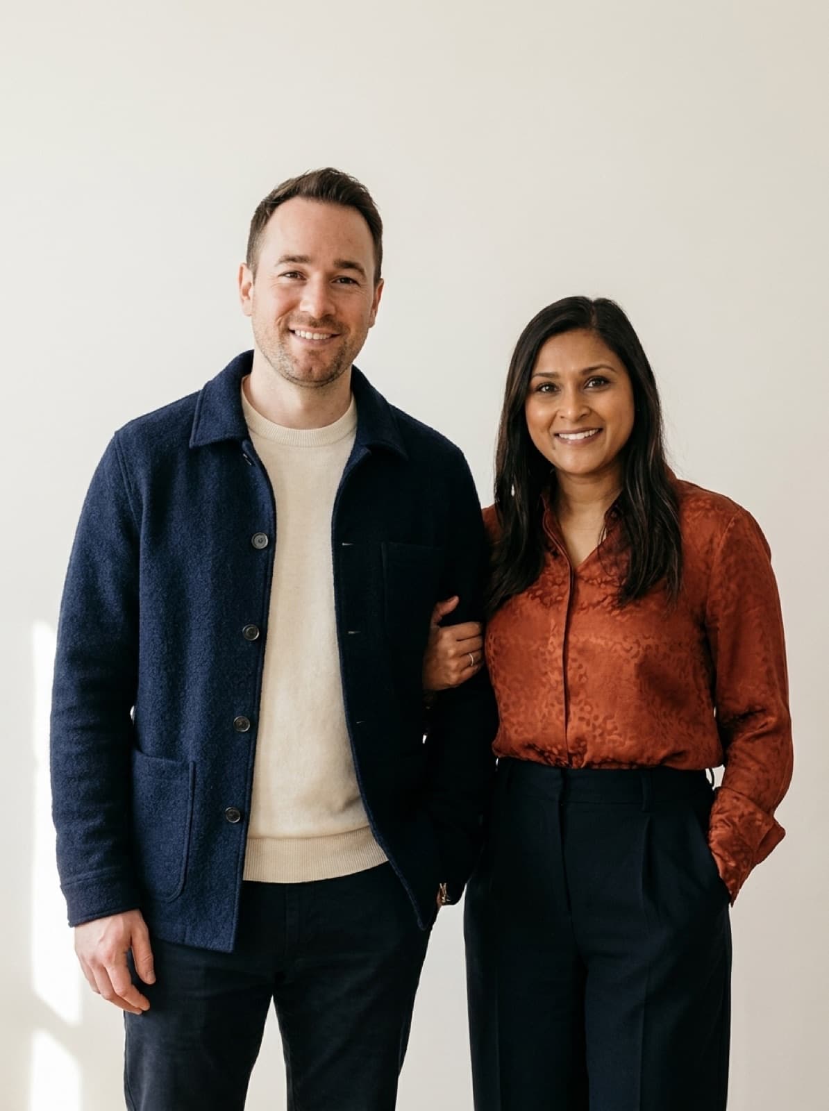 Rami and Melissa dressed sharp, arm in arm, smiling to camera